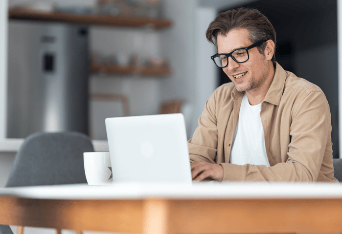 Happy businessman taking the CFTP training course on a computer while working at home-1