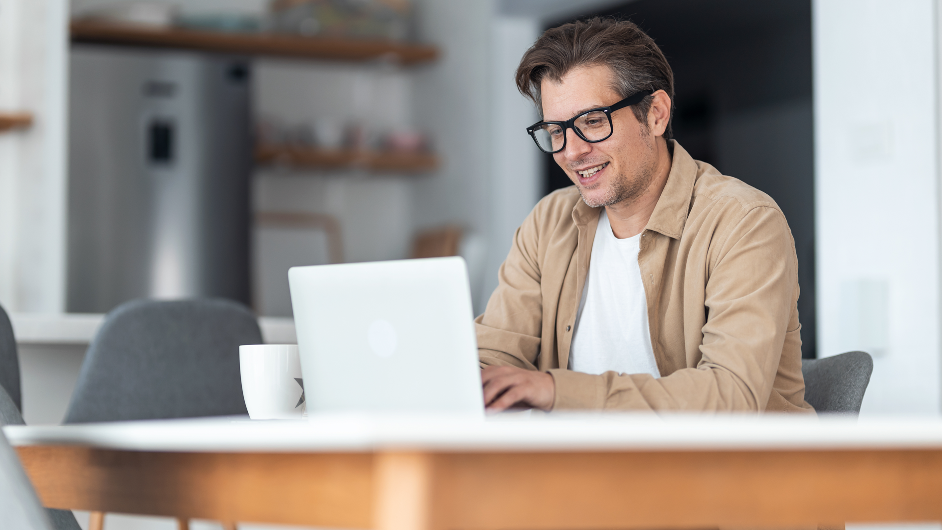 Happy businessman taking the CFTP training course on a computer while working at home