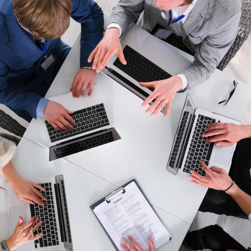 Three business professionals in suits reviewing financial reports, discussing file transfer processes and forensic accounting analysis in a modern office setting.
